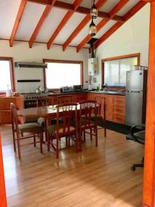 ロス・アンヘレスにあるLinda y cómoda cabaña en un entorno naturalのキッチン(テーブル、椅子、冷蔵庫付)