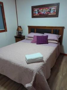 ロス・アンヘレスにあるLinda y cómoda cabaña en un entorno naturalのベッドルーム1室(大型ベッド1台、タオル2枚付)
