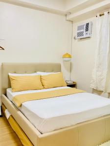 a bedroom with a large bed with yellow pillows at 17Eleven Staycation Home in Manila