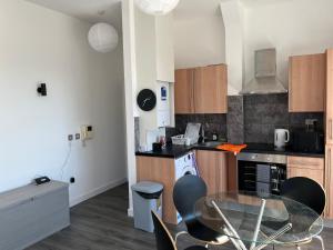 a kitchen with a glass table and chairs in it at Mordern Apartment in City Center in Manchester +16 photos