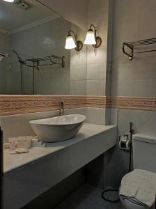 a bathroom with a bowl sink and a mirror at Hotel Salcedo De Vigan in Vigan