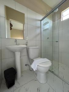 a bathroom with a toilet and a sink and a shower at Pôr do Sol Suítes in Lençóis