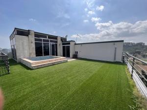 a building with a large yard with green grass at ZIRICH PROPERTIES EAST LEGON in Accra