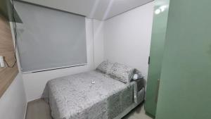 um pequeno quarto com uma pequena cama num quarto em Apto completo com 2 quartos à 3 minutos do Caribessa em João Pessoa