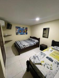 ein Schlafzimmer mit 2 Betten und einer Treppe darin in der Unterkunft Hotel heliconias mompox in Mompós