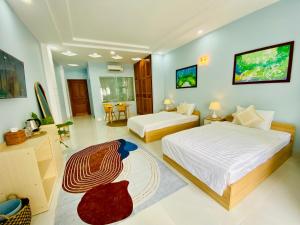 - une chambre avec 2 lits, un bureau et une télévision dans l'établissement NẮNG Homestel Tây Ninh, à Tây Ninh