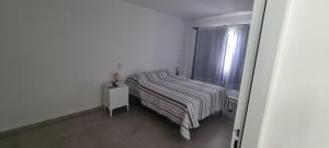 niewielka sypialnia z łóżkiem i oknem w obiekcie Marazul w mieście Las Grutas