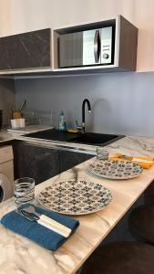 eine Küchentheke mit zwei Tellern und einer Mikrowelle in der Unterkunft Le B96 in Cayenne