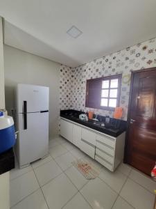 uma cozinha com um frigorífico branco e uma janela em Villas da serra 3 em Lagoa Nova
