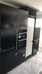 a black and white kitchen with a black refrigerator at Holiday home in DʼArbeau
