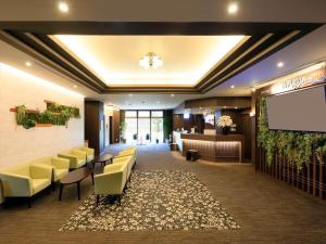 a lobby with a waiting room with yellow chairs and a projection screen at Hotel Futabanomori 