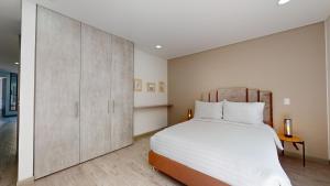 een slaapkamer met een groot bed en een grote kast bij Harmony Unicentro Suites Kappa in Bogota