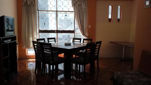 a dining room with a table and chairs and a window at Preciosa casa colonial in Quito