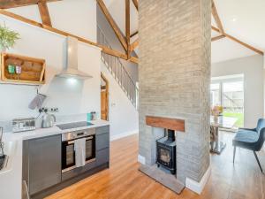 cocina y sala de estar con chimenea de ladrillo en Vallum Villa - Uk40231 en Bardon Mill