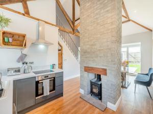 a kitchen and living room with a brick fireplace at Vallum Villa - Uk40231 in Bardon Mill