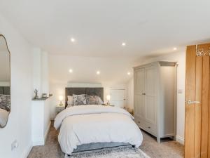 a white bedroom with a bed and a cabinet at Vallum Villa - Uk40231 in Bardon Mill