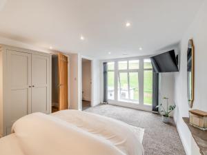 a white bedroom with a bed and a flat screen tv at Vallum Villa - Uk40231 in Bardon Mill