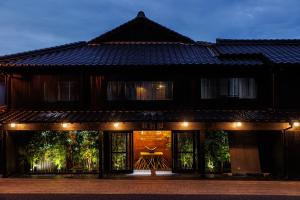 um edifício com as suas portas iluminadas à noite em 浜崎の宿萩別邸 em Hagi