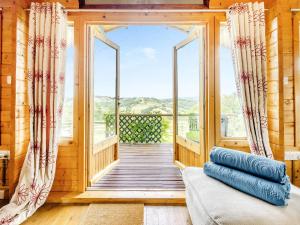um quarto com um alpendre com um sofá e uma janela em The Cabin Cefn Mawr em Highgate