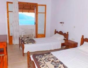 una camera con due letti e una finestra di House Anastasia ad Agios Georgios Pagon