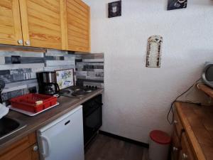 a small kitchen with a stove and a counter top at Confortable T2 avec balcon et parking à Jausiers - FR-1-165A-174 in Jausiers +3 photos