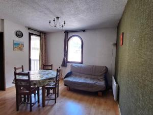 a living room with a table and a couch at Confortable T2 avec balcon et parking à Jausiers - FR-1-165A-174 in Jausiers