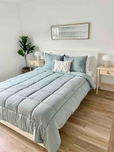 1 dormitorio con 1 cama grande con almohadas azules en OBX Dreamin’ en Kitty Hawk