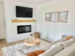 ein Wohnzimmer mit einem Sofa und einem Kamin in der Unterkunft OBX Dreamin’ in Kitty Hawk