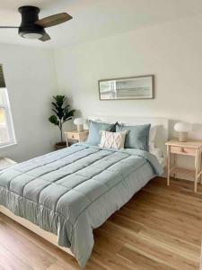 a bedroom with a large bed with blue pillows at OBX Dreamin’ in Kitty Hawk
