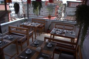 un restaurante con mesas y sillas en un balcón en Peshal Home, en Katmandú