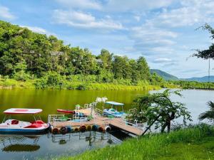 deux bateaux sont amarrés à un quai sur un lac dans l'établissement BlueHome Villa, à Hòa Bình