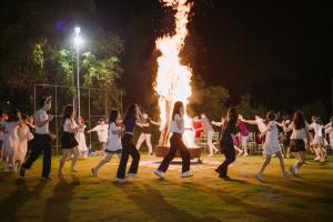 un grupo de personas bailando frente a un fuego en BlueHome Villa en Hòa Bình