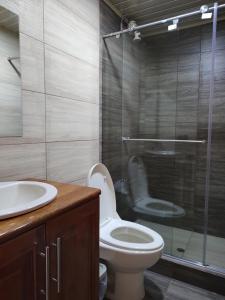 a bathroom with a toilet and a glass shower at Hotel RA04 in Chachagüí