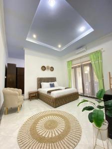 um quarto com uma cama, um sofá e uma cadeira em Villa Wangko em Tanjungkarang
