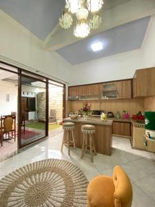 uma grande cozinha com uma mesa e bancos em Villa Wangko em Tanjungkarang