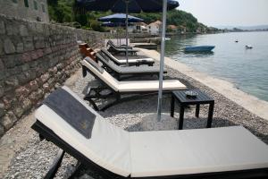 a group of tables and chairs next to the water at Apartments Villa Jelena in Tivat