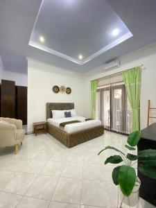 um quarto com uma cama e um sofá num quarto em Villa Wangko em Tanjungkarang