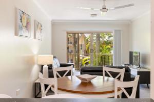 a living room with a table and chairs at Port Douglas Sands Resort in Port Douglas