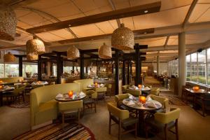 a restaurant with tables and chairs and a bar at Sails in the Desert in Ayers Rock