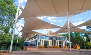 a large white umbrella in front of a building at Sails in the Desert in Ayers Rock
