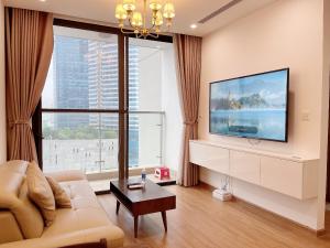 sala de estar con sofá y TV de pantalla plana en Vinhomes Skylake Apartments next to Keangnam,High floor City view with Balcony, en Hanói