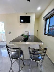 eine Küche mit einem Tisch mit 2 Stühlen und einem TV in der Unterkunft Isla Bonita - Isla Mujeres centro in Isla Mujeres