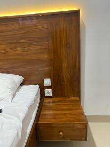 una camera con letto e testiera in legno di Umyas Hotel Syariah a Nganjuk