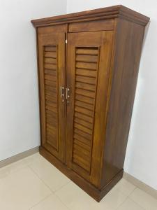 a wooden cabinet with two doors on a wall at Umyas Hotel Syariah in Nganjuk