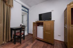 um quarto com uma pequena mesa e uma televisão num armário em Inkarri Regocijo Plaza em Cusco