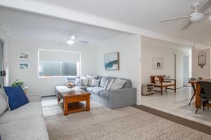 ein Wohnzimmer mit Sofa und Tisch in der Unterkunft Evans Beach House - 24 Cedar Street in Evans Head