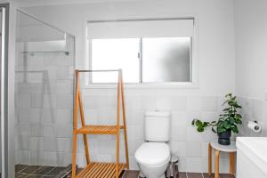 ein weißes Bad mit einem WC und einem Fenster in der Unterkunft Evans Beach House - 24 Cedar Street in Evans Head + 7 Fotos