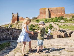 uma menina e um menino em pé nas ruínas de um castelo em 4 person holiday home in Allinge em Allinge