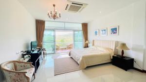 1 dormitorio con cama, escritorio y ventana en Baan Ing Khao, en Pak Chong