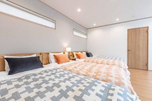 1 dormitorio con 2 camas y 2 ventanas en PEACE OF REST SHIRAHAMA, en Shirahama